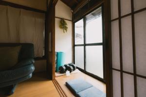 a living room with a couch and a window at Kominka Hakone Entire Traditional House in Hakone