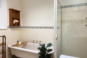 a bathroom with a white tub and a shower at Hidden Getaway in the City in Mount Gambier +12 photos