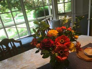 a vase filled with flowers sitting on a table at Hawk's Nest Bed & Breakfast in Bathurst