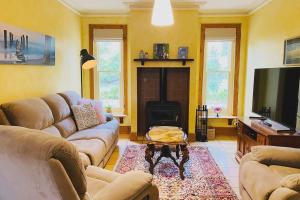 a living room with couches and a tv and a fireplace at Hidden Getaway in the City in Mount Gambier