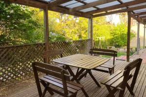 a wooden picnic table and two chairs on a deck at Hidden Getaway in the City in Mount Gambier