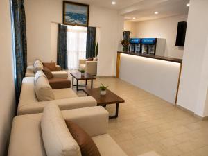 a large living room with couches and a tv at Hotel Albatros Wallis in Alele