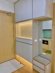 a kitchen with white cabinets and a glass door at Green Chill Studio in An Khê