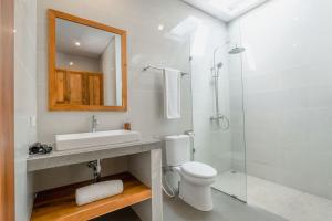 a bathroom with a toilet and a sink and a shower at Villa Bawa in Ubud +2 photos