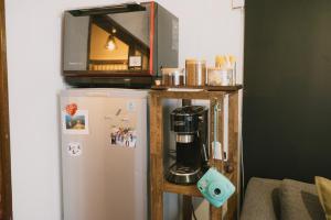 a coffee maker on a shelf next to a refrigerator at Kominka Hakone Entire Traditional House in Hakone +25 photos