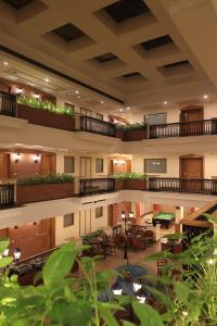 a large lobby with tables and chairs in a building at Savoy Suites Noida in Noida