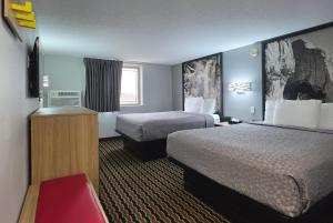 a hotel room with two beds and a television at Super 8 by Wyndham Yankton in Yankton