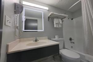 a bathroom with a sink and a toilet and a mirror at Super 8 by Wyndham Yankton in Yankton