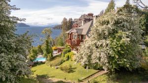 an aerial view of a house on the shore of a lake at Charming Residences & Suites with Private Spa in San Carlos de Bariloche