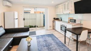 a living room with a couch and a table in a kitchen at Studio 66 Busselton in Busselton