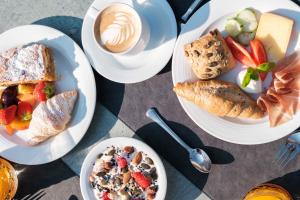 a table with plates of food and a cup of coffee at Hotel Goldenes Roessl-adults only in Bressanone