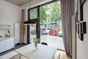 Modern Design Apartment في برلين: مطبخ مع طاولة بيضاء ونافذة كبيرة