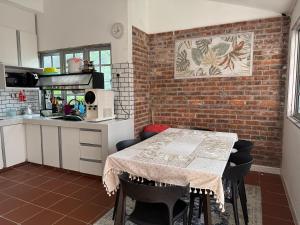 a kitchen with a table and a brick wall at Dynz Cottage in Banting
