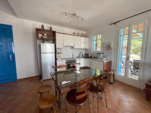 a kitchen with a table and chairs and a refrigerator at Vila Cleopatra Andros Greece in Andros