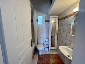 a white bathroom with a toilet and a sink at Vila Cleopatra Andros Greece in Andros +33 photos