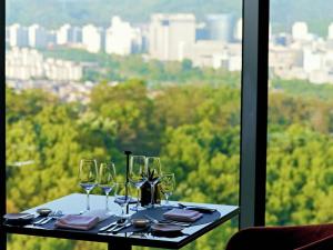 a table with wine glasses sitting on top of a window at DoubleTree By Hilton Seoul Pangyo in Seongnam