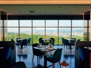 a restaurant with tables and chairs and large windows at DoubleTree By Hilton Seoul Pangyo in Seongnam +198 photos