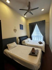 two beds in a room with a ceiling fan at VH HOMES l Imago Mall l 2BR Family Suite l Garden Direct Access in Kota Kinabalu +45 photos