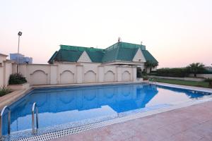 a swimming pool in front of a house at Savoy Suites Noida in Noida
