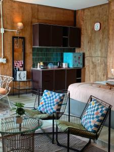 a bedroom with a bed and two chairs and a table at Baan Sahai Tone บ้านสหายโทน in Ko Larn