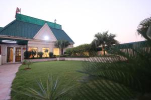 a house with a green lawn in front of it at Savoy Suites Noida in Noida