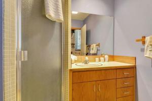 a bathroom with a sink and a shower with a mirror at Meadow House 21 in Sunriver +15 photos