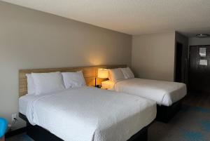 a hotel room with two beds and a lamp at Days Inn by Wyndham Sault Ste Marie MI in Sault Ste. Marie