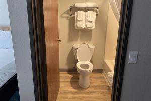 a small bathroom with a toilet and towels at Days Inn by Wyndham Sault Ste Marie MI in Sault Ste. Marie