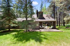 a house with a patio and chairs in the yard at Meadow House 21 in Sunriver