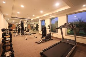 a gym with several treadmills and machines in a room at Savoy Suites Noida in Noida