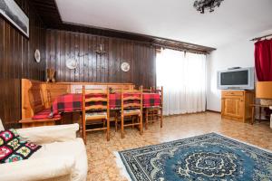 a living room with a table and chairs and a tv at Appartamento Da Sergio in Bormio