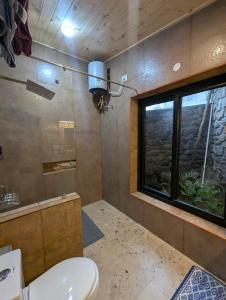 a bathroom with a toilet and a window at Cloudwalks Homestay in Kodaikānāl +244 photos
