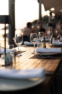 a wooden table with wine glasses and napkins on it at Vincci EverEden in Anavyssos