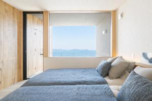 a bedroom with a large bed with a large window at Villa CASK Setouchi in Mitoyo