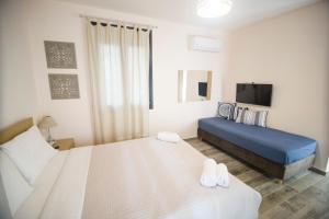 a bedroom with two beds and a flat screen tv at Villa Saravari in Áyios Aléxandros