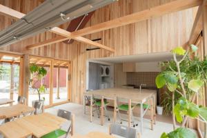 an open kitchen and dining room with wooden walls and tables at ホテル聚 - Hotel SHU in Tonosho