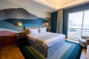 a hotel room with a bed and a large window at Warwick Palm Beach Hotel in Beirut +31 photos