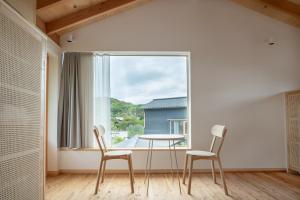 a dining room with a table and two chairs and a window at ホテル聚 - Hotel SHU in Tonosho +33 photos