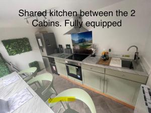 a kitchen with a sink and a stove top oven at Cosy cabin with private bathroom in Bircotes