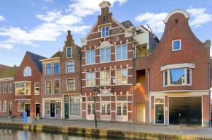 a large brick building next to a canal at BNB de Victorie Alkmaar in Alkmaar