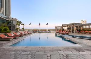 a swimming pool on a building with chairs and buildings at Hilton Panama in Panama City