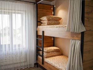 a bunk bed with pillows in a room with a window at Dolon Hostel in Bishkek