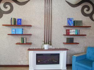 a living room with a fireplace and a blue couch at Dolon Hostel in Bishkek