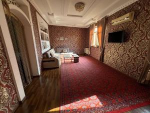 a living room with a couch and a red carpet at Hotel & Hostel Siyob Samarkand in Samarkand