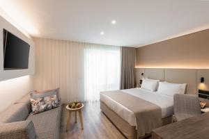 a hotel room with a bed and a couch at Vincci EverEden in Anavyssos