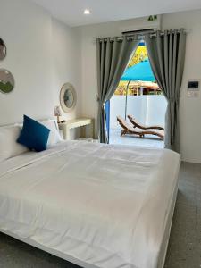 a bedroom with a large white bed and a patio at Laco Villa in Danang