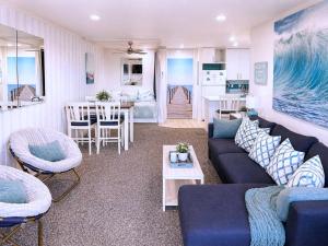 a living room with a blue couch and a table at SolMar Breeze - 1BR Condo at North Coast Village - Heated Pools, Hot Tubs & Steps to Beach, Oceanside Harbor and Pier in Oceanside