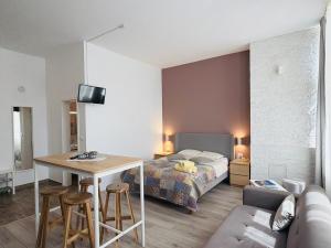 a bedroom with a bed and a table and a couch at Sunny Studio Apartment in Iaşi