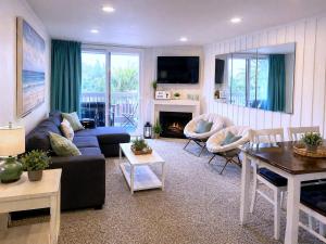 a living room with a couch and a fireplace at SolMar Breeze - 1BR Condo at North Coast Village - Heated Pools, Hot Tubs & Steps to Beach, Oceanside Harbor and Pier in Oceanside