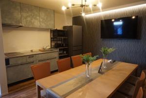 a dining room with a table and a kitchen at Stella Casa in Gotemba